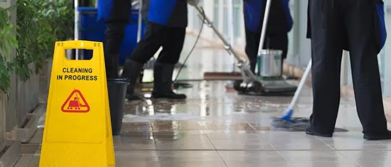 Equipo de limpieza trapeando y encerando pisos