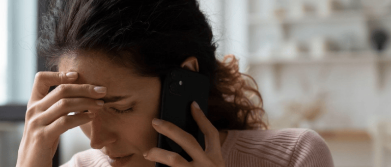 mujer frustrada por teléfono con un ajustador de la aseguradora de tu coche
